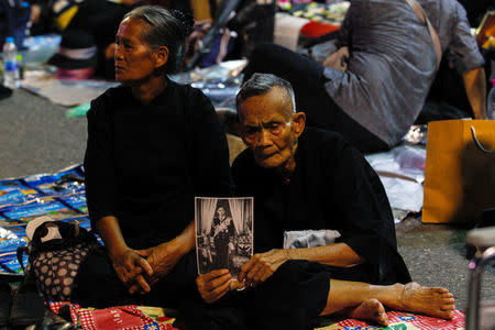 A well-wisher holds up a portrait of late Thailand's King Bhumibol Adulyadej during his funeral rehearsal near the Grand Palace in Bangkok, Thailand October 21, 2017. REUTERS/Kerek Wongsa