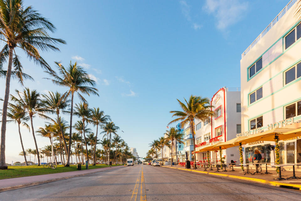 Photo of Ocean Drive with palm tree lined streets and art deco buildings