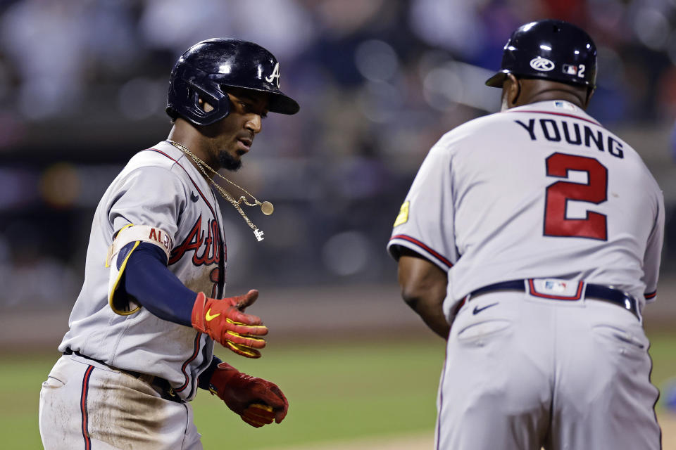 Atlanta Braves' Ozzie Albies is congratulated by first base coach Eric Young Sr. (2) after Albies hit a two-run home run against the New York Mets during the ninth inning in the second baseball game of a doubleheader Saturday, Aug. 12, 2023, in New York. (AP Photo/Adam Hunger)