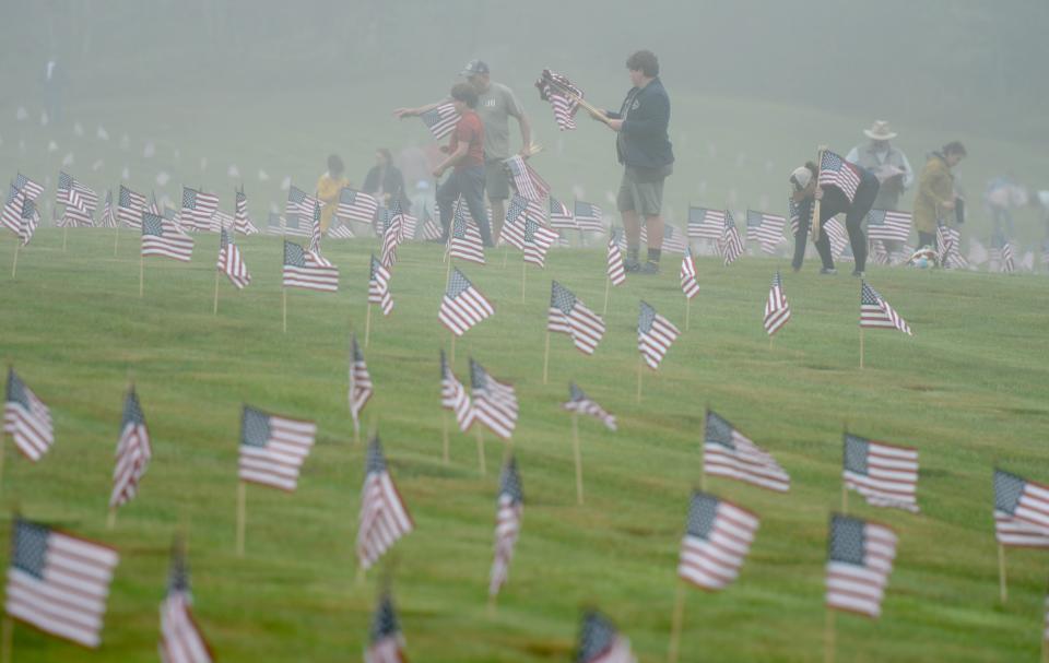 The fog shrouds the landscape on Saturday at the National Cemetery in Bourne where hundreds of volunteers gathered to place tens of thousands of flags on all the veterans' grave in honor of Memorial Day. Steve Heaslip/Cape Cod Times