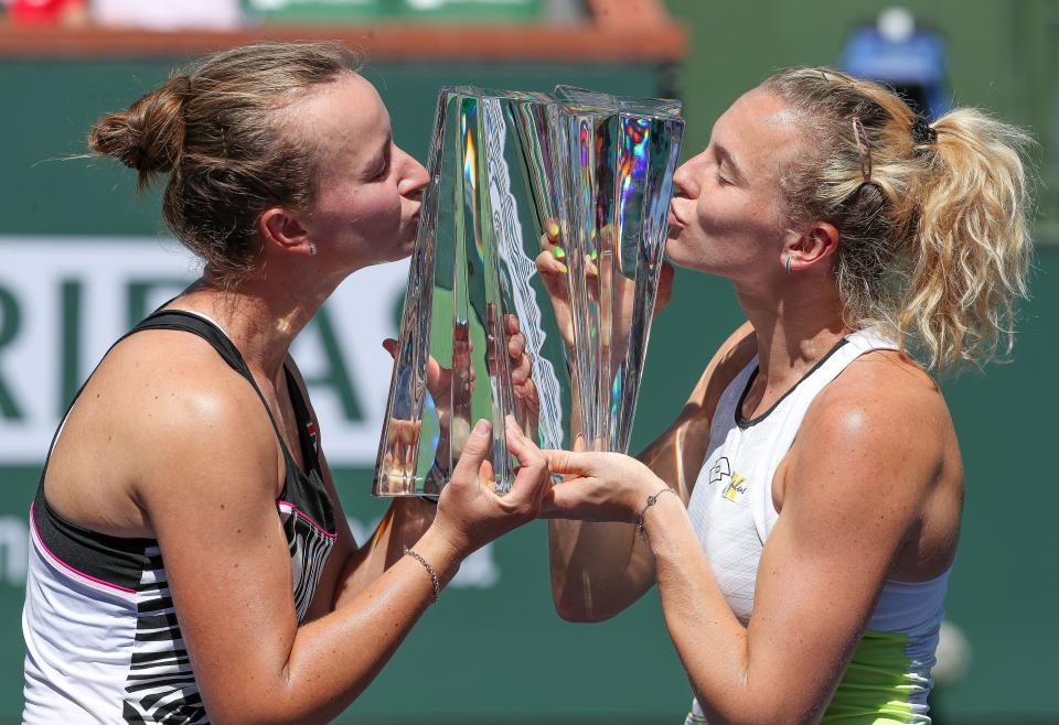 Katerina Siniakova, right, and Barbora Krejcikova kiss the trophy as the women's doubles champions of the BNP Paribas Open at the Indian Wells Tennis Garden in Indian Wells, Calif., March 18, 2023.