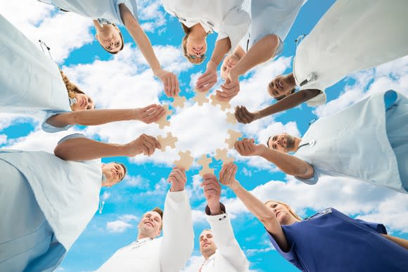 Doctors joining puzzle pieces together with a cloud in the background