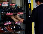A man chooses a pair of shoes at a shop in Tokyo