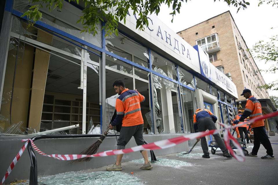 Moskau: Arbeiter fegen Glasscherben an einem beschädigten Gebäude nach einem Drohnenangriff (Bild: Uncredited/AP/dpa)