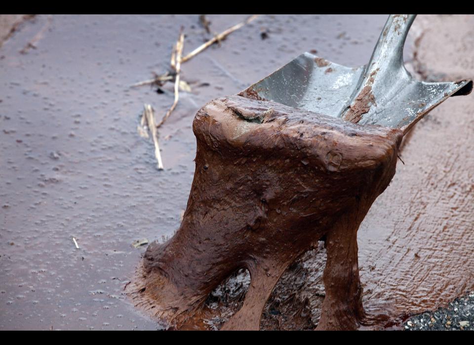 GULFPORT, MS - JULY 1:  An Oil cleanup worker uses a shovel to remove thick oil that washed ashore from the Deepwater Horizon oil spill in the Gulf of Mexico on July 1, 2010 in Gulfport, Mississippi. Millions of gallons of oil have spilled into the Gulf since the April 20 explosion on the drilling platform.  (Photo by Joe Raedle/Getty Images)