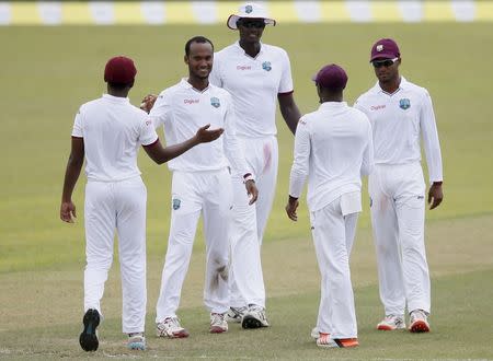 West Indies' Kraigg Brathwaite (2nd L) celebrates with teammates and team captain Jason Holder (C) after taking the wicket of Sri Lanka's Rangana Herath (not pictured) during the third day of their second test cricket match in Colombo October 24, 2015. REUTERS/Dinuka Liyanawatte.