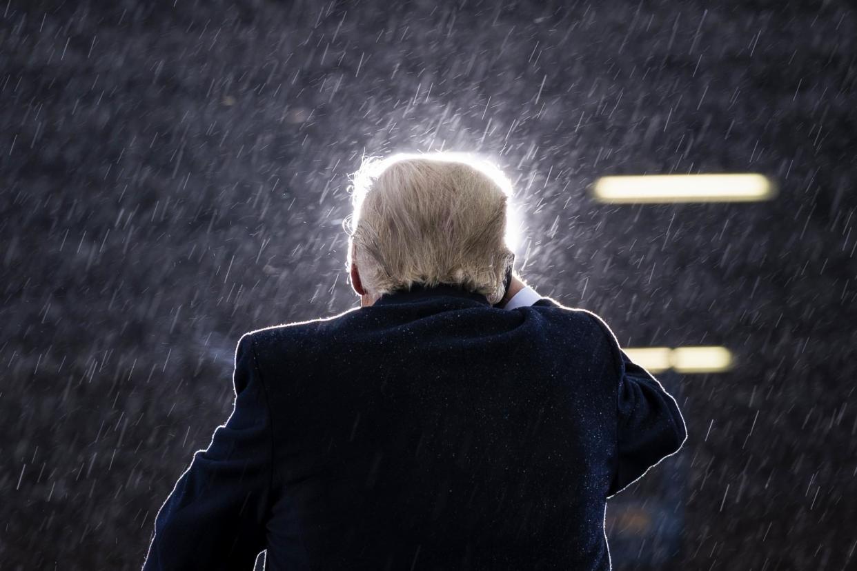 <span>Then-president Donald Trump campaigns in the rain in Lansing, Michigan, on 27 October 2020.</span><span>Photograph: Evan Vucci/AP</span>