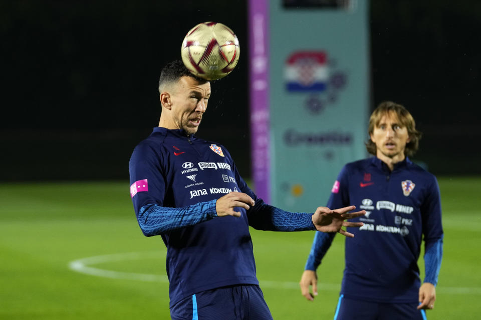 Croatia's Luka Modric, right, looks at Croatia's Ivan Perisic heading the ball during a training session of Croatia national team at the 2022 soccer World Cup in Doha, Sunday, Dec. 11, 2022. (AP Photo/Petr David Josek)