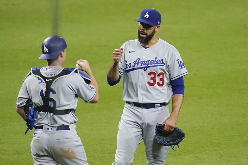 Dodgers reliever David Price and catcher Will Smith celebrate after shutting down the Padres in the 12th inning and securing a victory.