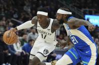 Brooklyn Nets' Dennis Schroder drives past Milwaukee Bucks' Patrick Beverley during the first half of an NBA basketball game Thursday, March 21, 2024, in Milwaukee. (AP Photo/Morry Gash)
