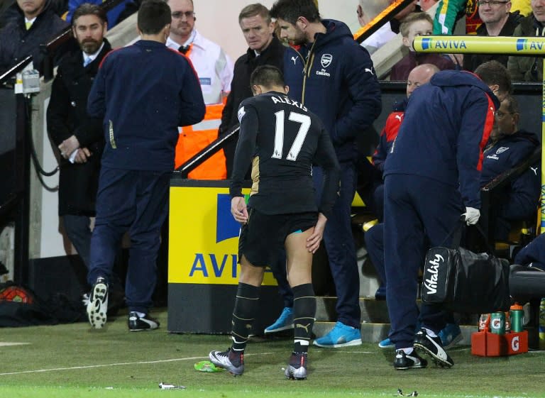 Arsenal's Chilean striker Alexis Sanchez limps off the pitch holding his leg during the English Premier League football match between Norwich City and Arsenal at Carrow Road in Norwich, eastern England on November 29, 2015