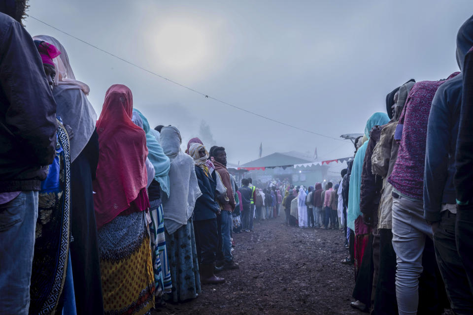 Ethiopians queue in the early morning to cast their votes in the general election, in Prime Minister Abiy Ahmed's home town of Beshasha, in the Oromia region of Ethiopia Monday, June 21, 2021. Ethiopia began voting Monday in the greatest electoral test yet for Prime Minister Abiy Ahmed as war and logistical issues meant ballots wouldn't be cast in more than 100 of the 547 constituencies across the country. (AP Photo/Mulugeta Ayene)