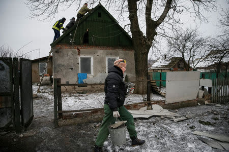 A local resident is seen as Emergencies Ministry members repair her home which was damaged during fighting between the Ukrainian army and pro-Russian separatists in the government-held industrial town of Avdiyivka, Ukraine, February 6, 2017. REUTERS/Gleb Garanich