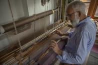 Gulzar Ahmed Want, a Kashmiri artisan, weaves a pashmina shawl on a loom inside his home in Srinagar, Indian controlled Kashmir, Saturday, June 13, 2020. A months-long military standoff between India and China has taken a dire toll on local communities as tens of thousands of Himalayan goat kids die because they couldn't reach traditional winter grazing lands, officials and residents said. Nomads have roamed these lands atop the roof of the world for centuries, herding the famed and hardy goats that produce the ultra-soft wool known as Pashmina, the finest of cashmeres. Cashmere takes its name from the disputed Kashmir valley, where artisans weave the wool into fine yarn and exquisite shawls that cost up to $1,000 apiece in world fashion capitals in a major handicraft export industry that employs thousands. (AP Photo/Dar Yasin)