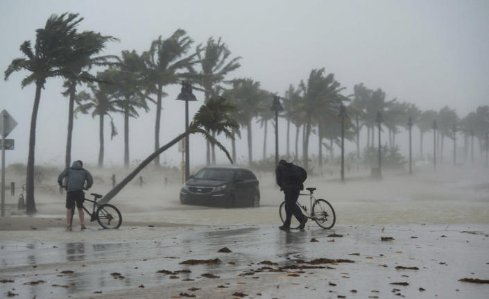 <p><strong>Fort Lauderdale</strong><br> Two men walk their bicycle along a flooded street on the waterfront of Fort Lauderdale, Fla., as Hurricane Irma passes through on Sept. 10, 2017. (Photo: Paul Chiasson/The Canadian Press via AP) </p>