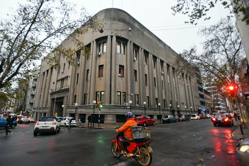 Commuters pass by the "Carcel Central de Montevideo" in Montevideo, Uruguay, Monday, June 24, 2019. Top Italian organized crime boss, Rocco Morabito, escaped before dawn Monday from this prison where he was awaiting extradition to Italy, according to Uruguay’s interior ministry. (AP Photo/Matilde Campodonico)