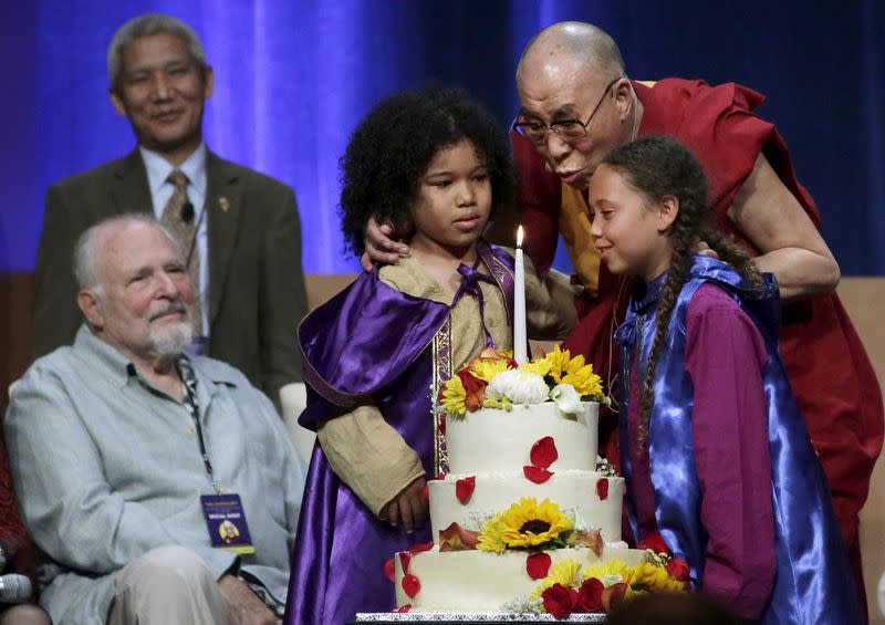 FILE PHOTO: A group of children help the Dalai Lama blow out a candle on his birthday cake at the University of California, Irvine