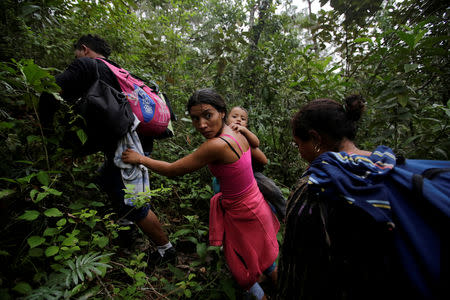 Honduran migrants hike in the forest after crossing the Lempa river, in the border line between Honduras and Guatemala to join a caravan trying to reach the U.S, in Guatemala, October 17, 2018. REUTERS/Jorge Cabrera/File photo