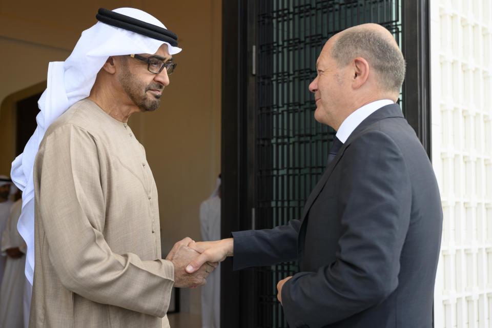 In this photo made available by the United Arab Emirates Presidential Court, Sheikh Mohamed bin Zayed Al Nahyan, President of the UAE left, shakes hands with German Chancellor Olaf Scholz, at Al Shati Palace in Abu Dhabi, United Arab Emirates, Sunday, Sept. 25, 2022. (Mohamed Al Hammadi/UAE Presidential Court via AP)