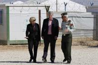 Canada's Prime Minister Stephen Harper (C) and his wife Laureen (L), listen to Major General Omar al-Khalidi, head of the Planning Commission of the Jordanian army, during a tour at the main center of the World Food Program during their visit to Al Zaatari refugee camp, in the Jordanian city of Mafraq, near the border with Syria January 24, 2014. REUTERS/Muhammad Hamed