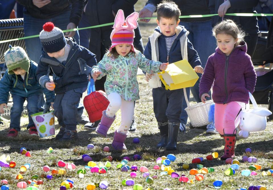 Youngsters, above, scramble to fill their baskets during the Newport Recreation Department Easter egg hunt at Touro Park in Newport.
