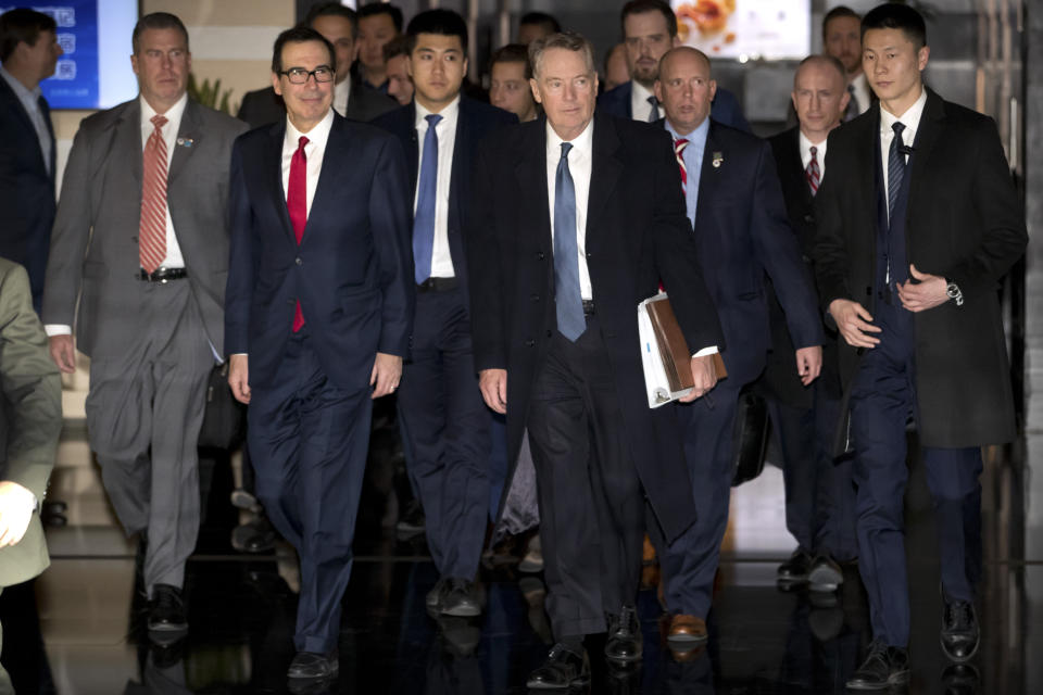 U.S. Treasury Secretary Steven Mnuchin, second from left, and U.S. Trade Representative Robert Lighthizer, fourth from left, walk together as they leave their hotel in Beijing, Friday, Feb. 15, 2019. U.S. and Chinese negotiators opened talks Thursday on a sprawling trade dispute as Beijing reported its January exports rebounded despite President Donald Trump's tariff hikes. (AP Photo/Mark Schiefelbein)