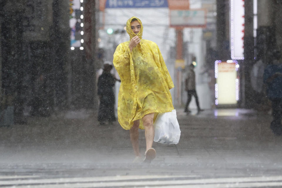 A man makes his way through the heavy rain caused by a powerful typhoon in Kagoshima, southern Japan, Sunday, Sept. 18, 2022. (Kyodo News via AP)