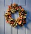 <p>You know those long garlands of fake fall foliage? Fashion one into a wreath by wrapping it around a round bundle of chicken wire, adjusting until it looks exactly how you'd like it. If there are any bare spots, stick in some loose fake foliage or pine cones. </p>