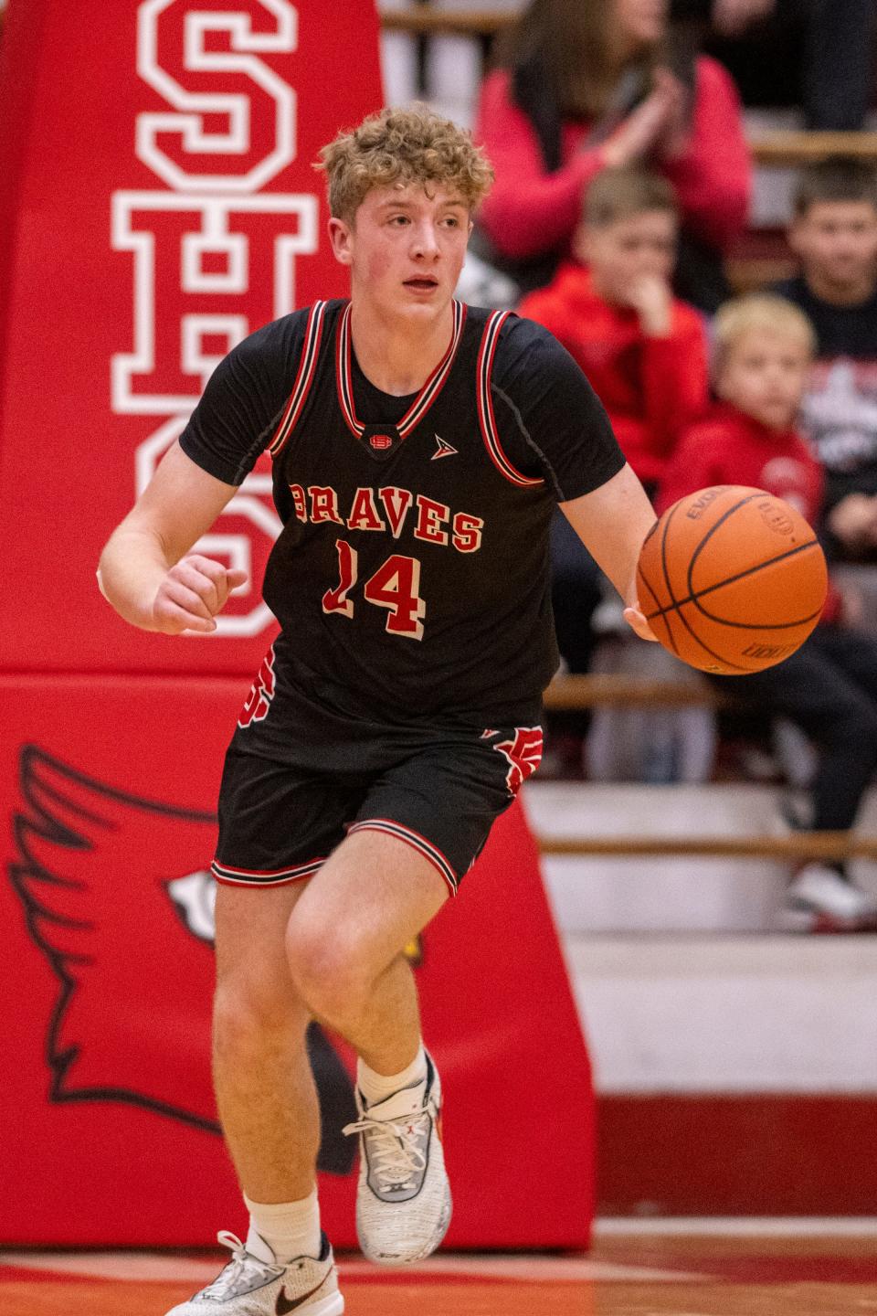 Brownstown Central High School junior Jack Benter (14) brings the ball up court during the first half of an IHSAA Class 2A Semi-State semi-final basketball game against Indianapolis Scecina Memorial High School , Saturday, March 18, 2023, at Southport High School.