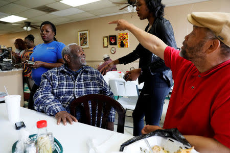 Henry Leach (L), talks with his granddaughters and his friend Clarence Christian (R) at his family's Ms. Girlees's Soul Food Restaurant in Memphis, Tennessee, U.S., March 26, 2018. Leach, who participated in the strike 50 years ago, said King came to the city for justice, not violence. "He came to help us get what we wanted. Like I tell you, he became like a father to us," the former sanitation worker said recently. REUTERS/Jonathan Ernst