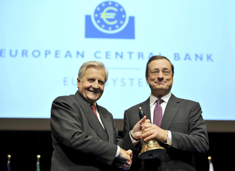 FILE - In this Oct. 19, 2011 file photo outgoing European Central Bank (ECB) President Jean-Claude Trichet, left, hands over a bell to his successor Mario Draghi from Italy at the end of a farewell ceremony at the old opera house in Frankfurt, Germany. Draghi officially takes over as head of the ECB on Tuesday, Nov. 1, 2011, in a high-pressure struggle with eurozone government leaders over how far the bank should go in rescuing indebted governments. (AP Photo/Arne Dedert, pool)