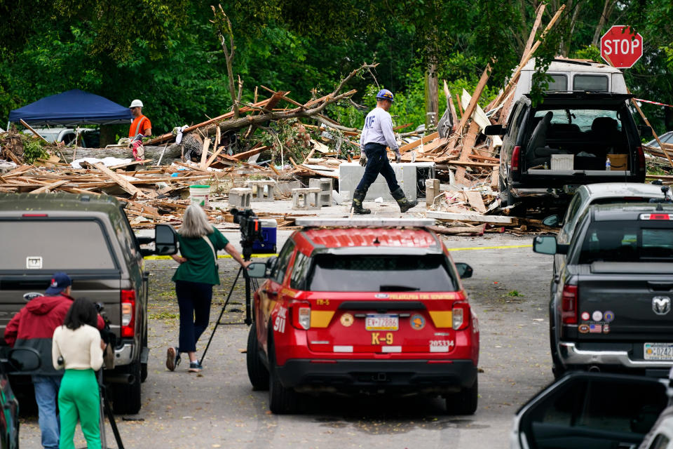 An investigator, center top, moves through the scene of a deadly explosion in a residential neighborhood in Pottstown, Pa., Friday, May 27, 2022. A house exploded northwest of Philadelphia, killing several people and leaving a few others injured, authorities said Friday. (AP Photo/Matt Rourke)
