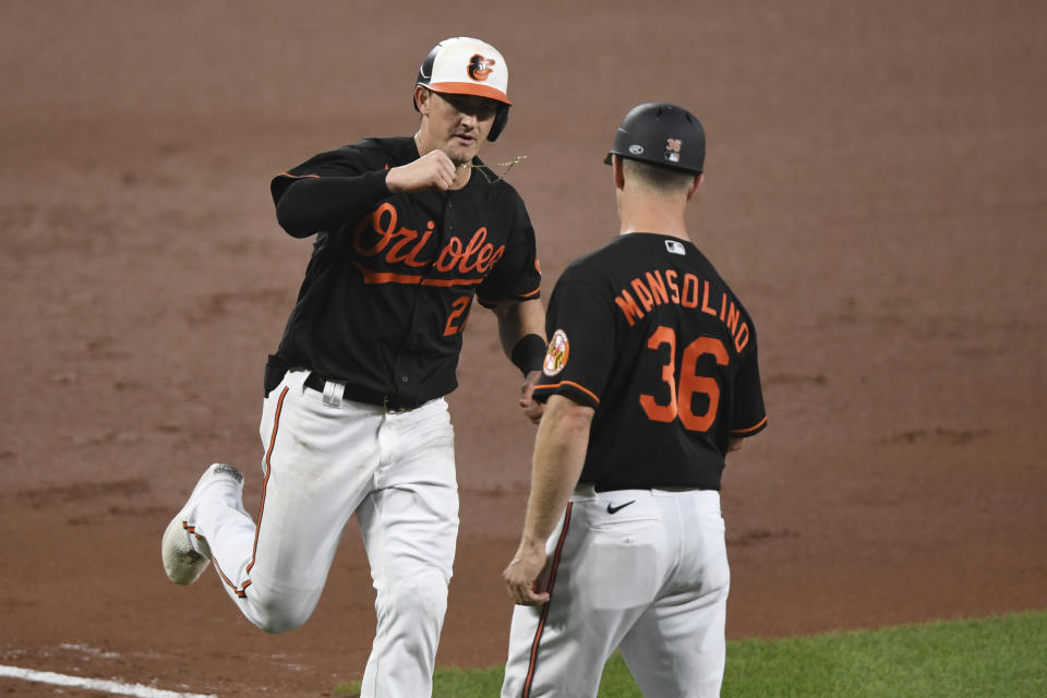 Baltimore Orioles' Austin Hays is greeted by third base coach Tony Mansolino after a solo home run off Miami Marlins starting pitcher Sandy Alcantara during the fourth inning of a baseball game Tuesday, July 27, 2021, in Baltimore. (AP Photo/Terrance Williams)