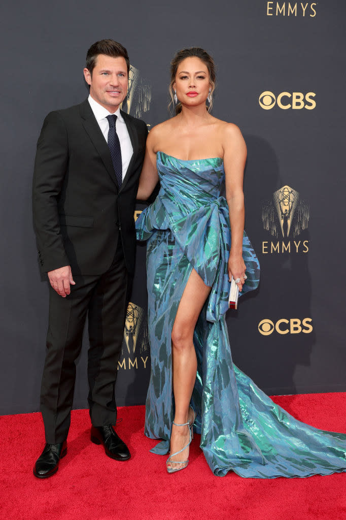 Nick Lachey wears a dark suit and Vanessa Lachey wears a brightly colored strapless gown
