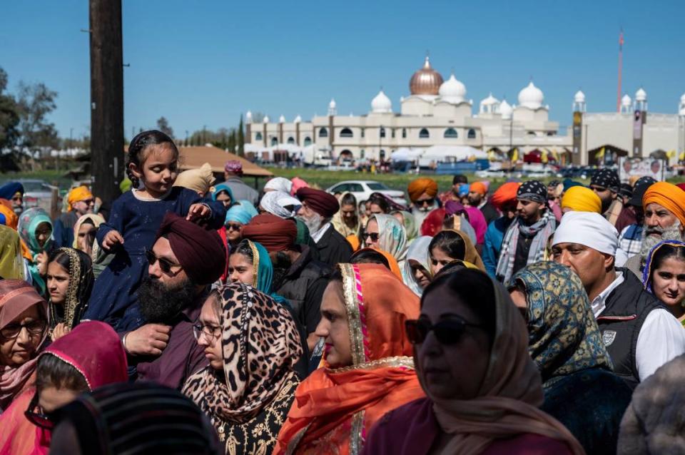 People fill one side of Bradshaw Road as they walk past the Sacramento Sikh Society temple in Vineyard on Sunday, March 26, 2023, during the society’s first Nagar Kirtan parade.