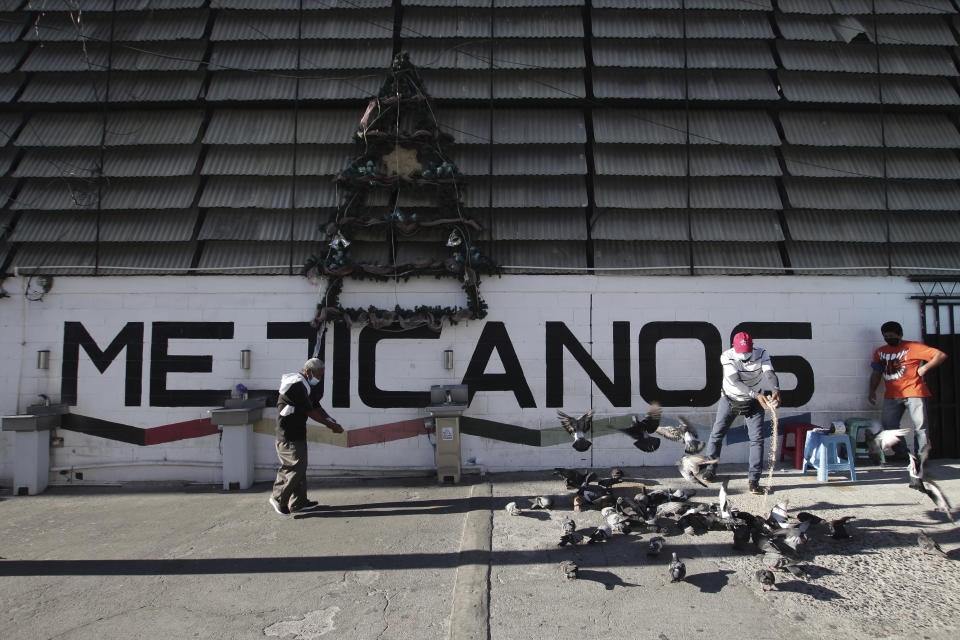 Un hombre alimenta palomas en la entrada del Mercado Municipal en Mejicanos, distrito de San Salvador, El Salvador, el domingo 4 de abril de 2021. Este distrito obrero fue bastión del partido Frente Farabundo Martí de Liberación Nacional (FMLN), pero durante las elecciones del 28 de febrero votó por Nuevas Ideas, el partido del presidente Nayib Bukele, quien había sido expulsado del FMLN. (Foto AP/Salvador Meléndez)