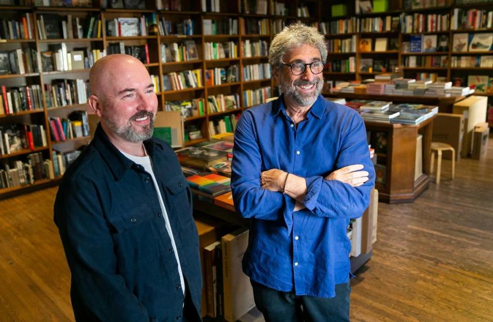 El autor Douglas Stuart, a la izquierda, habla con el propietario de Books & Books, Mitchell Kaplan, en su tienda de Coral Gables, Florida, el lunes 25 de abril de 2022.