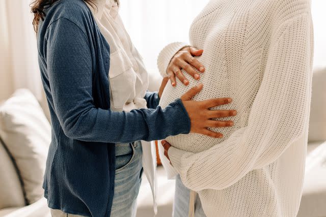 <p>Getty</p> Stock image of woman touching the belly of a pregnant woman