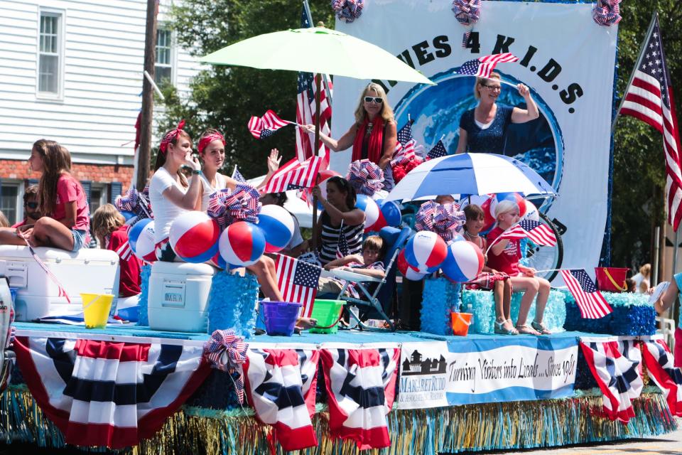 Parade participants wave to spectators during the NC 4th of July Festival Parade Friday, July 4, 2014 in Southport, N.C.