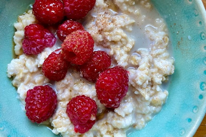 Raspberries on top of creamy oatmeal.