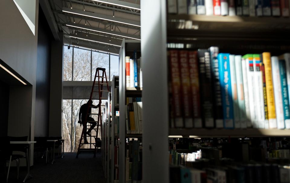 Anthony Heinmiller, a data technician with Excel Management Systems Inc., one of the contractors working on the new Gahanna library branch, climbs down a ladder on Wednesday. The Columbus Metropolitan Library will officially open the branch Saturday as a replacement branch for one that was originally built in 1991 and was no longer big enough.