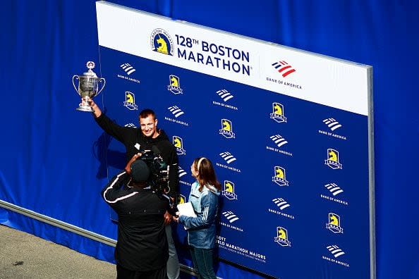 BOSTON, MASSACHUSETTS - APRIL 15: Boston Marathon Grand Marshal and former New England Patriot Rob Gronkowski shows off the winner's trophy at the finish line during the 128th Boston Marathon on April 15, 2024 in Boston, Massachusetts. (Photo by Omar Rawlings/Getty Images)