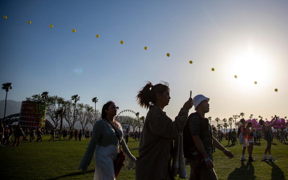 Festivalgoers walk by 'Balloon Chain' by Robert Bose during the Coachella Valley Music and Arts Festival at the Empire Polo Club in Indio, Calif., Friday, April 14, 2023. 
