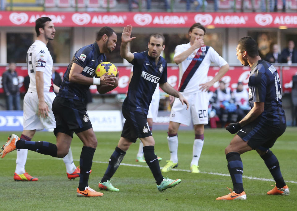 Inter Milan defender Jorge Rolando, second from left, of Portugal, holds the ball after scoring during the Serie A soccer match between Inter Milan and Cagliari at the San Siro stadium in Milan, Italy, Sunday, Feb. 23, 2014. (AP Photo/Antonio Calanni)