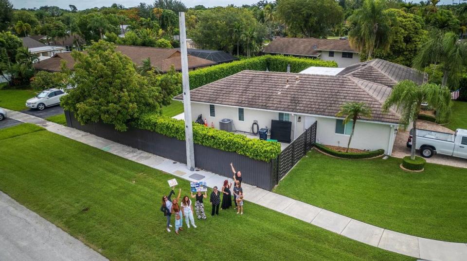 A group of residents concerned over 5G towers popping up in Kendall neighborhoods poses next to a pole behind a house at 11495 SW 101 Terrace on Friday, July 5, 2024.