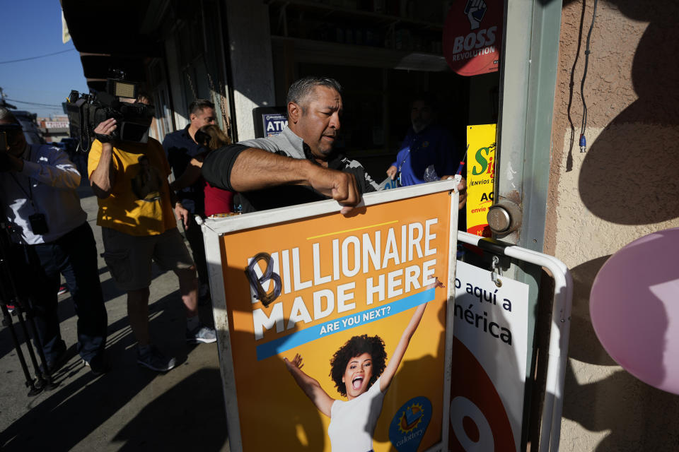 Hector Avalos puts up a sign outside the Las Palmitas Mini Market where the winning Powerball lottery ticket was sold in downtown Los Angeles, Thursday, July 20, 2023. The winning ticket for the Powerball jackpot is worth an estimated $1.08 billion and is the sixth largest in U.S. history and the third largest in the history of the game. (AP Photo/Marcio Jose Sanchez)