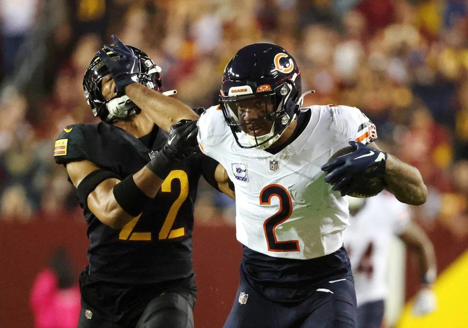 Chicago Bears wide receiver DJ Moore (2) stiff-arms Washington Commanders safety Darrick Forrest (22) to pick up extra yardage after a first-quarter pass reception at FedEx Field on Thursday, Oct. 5, 2023, in Landover, Maryland. (Stacey Wescott/Chicago Tribune/TNS) Stacey Wescott/TNS