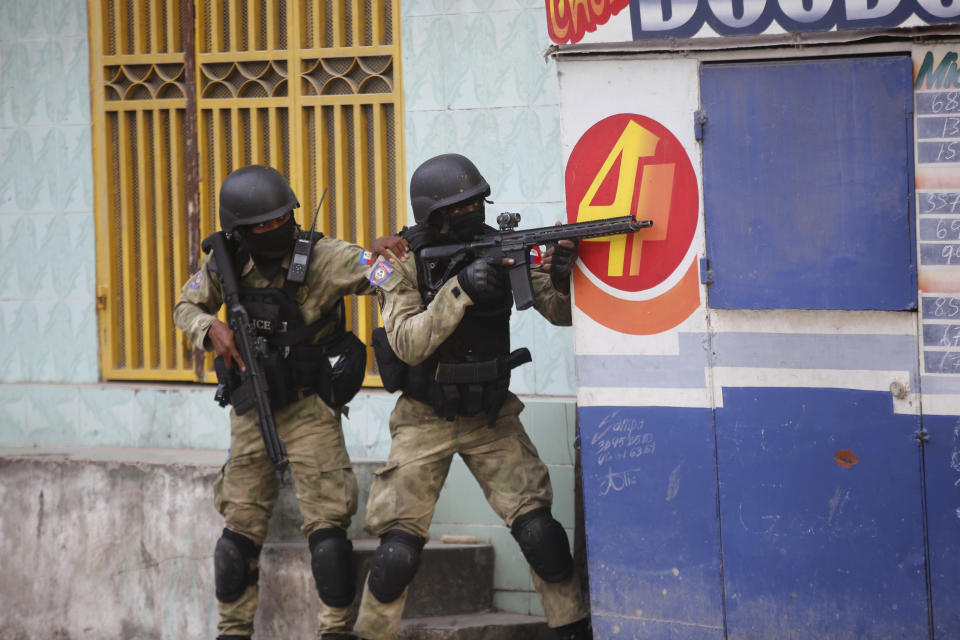 Police take cover during an anti-gang operation at Portail neighborhood in Port-au-Prince, Haiti, Thursday, Feb. 29, 2024. Gunmen shot at the international airport and other targets in a wave of violence that forced businesses, government agencies and schools to close early. (AP Photo/Odelyn Joseph)