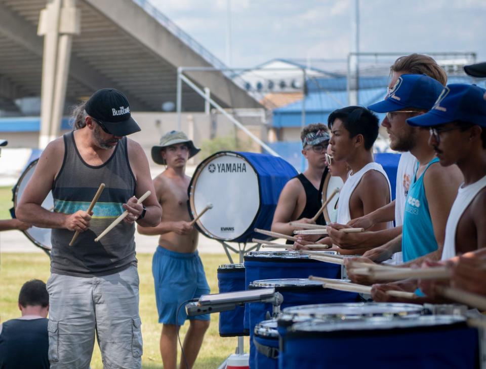 Bluecoats Drum and Bugle Corps member Roger Carter leads the drumline during practice Wednesday at Dix Stadium in Kent. The drum corps, which marks its 50th anniversary this year, kicked off the competition season earlier this week with a first-place win in Detroit.