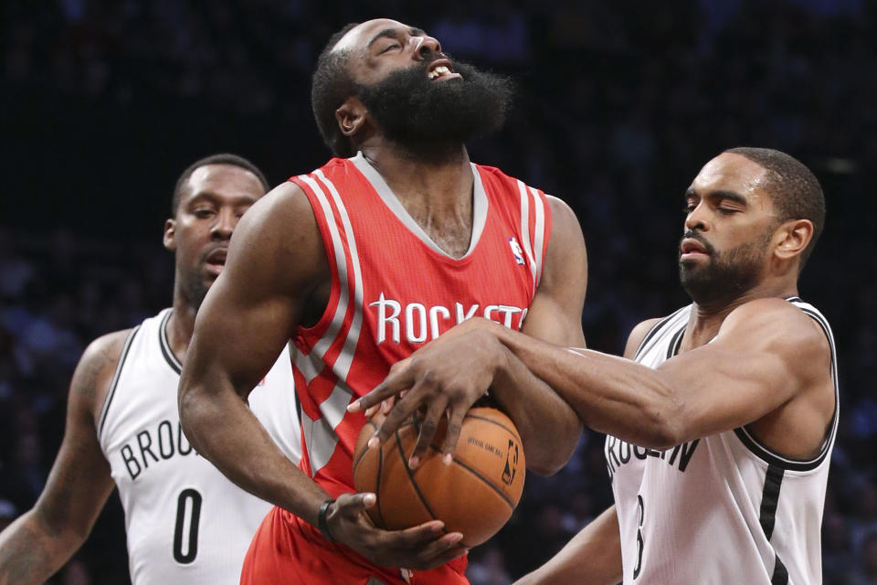 Houston Rockets guard James Harden (13) is fouled by Brooklyn Nets forward Alan Anderson, right, as center Andray Blatche (0) looks on during the second half of their NBA basketball game at the Barclays Center, Tuesday, April 1, 2014, in New York. (AP Photo/John Minchillo)